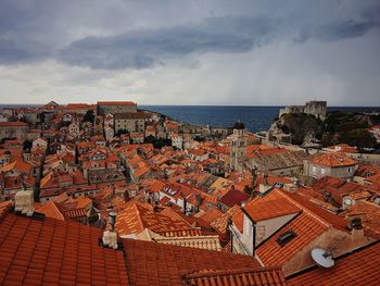 High angle view of town by sea against sky