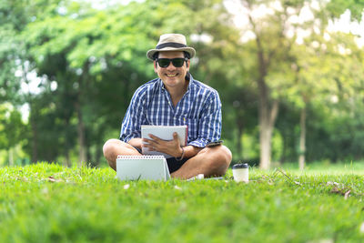 Young man using mobile phone while sitting on grass