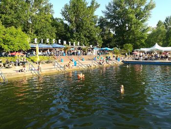 People swimming in pool by lake