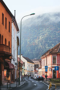 Brasov, romania, 29th of july 2022 - curving street with cars and mountains in the distance