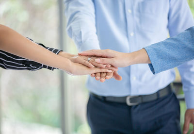 Midsection of business people stacking hands at office