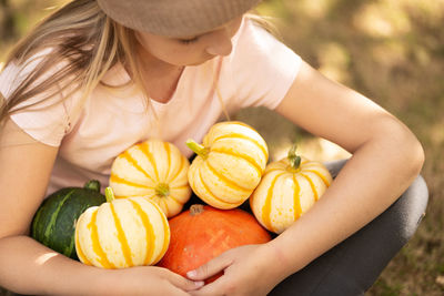 Midsection of woman holding pumpkins