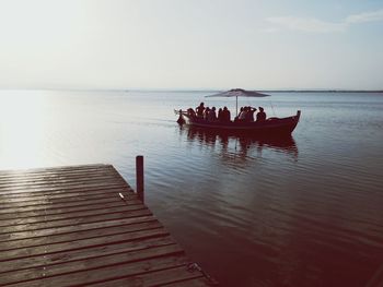 Silhouette boat in calm sea against clear sky