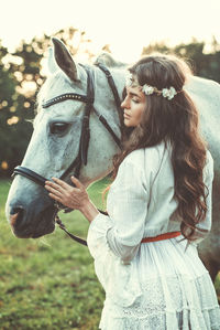 Rear view of woman with horse on field