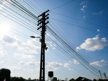 Low angle view of silhouette electricity pylon against sky