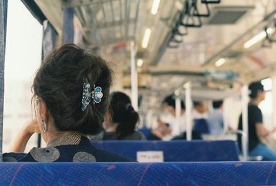 Rear view of woman sitting at train