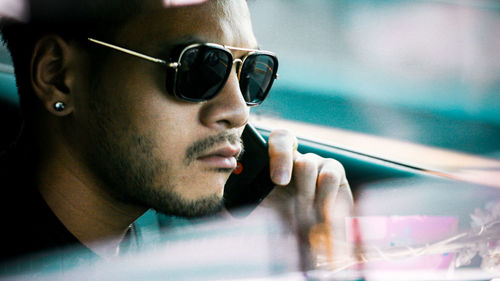 Portrait of man wearing sunglasses sitting outdoors