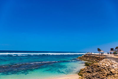 Scenic view of beach against clear blue sky