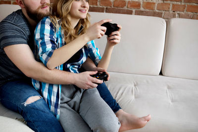 Happy friends sitting on sofa