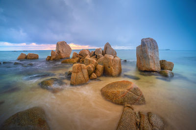 Rocks on beach against sky