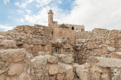 Low angle view of old building against cloudy sky