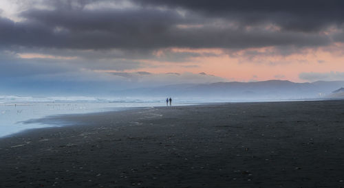 Scenic view of beach against sky during sunset