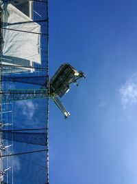 Low angle view of skyscraper against blue sky