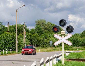 Red traffic light at the railway crossing. warning sign before the railway crossing