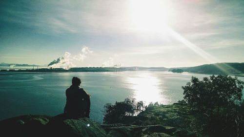 Rear view of silhouette man looking at sea against sky