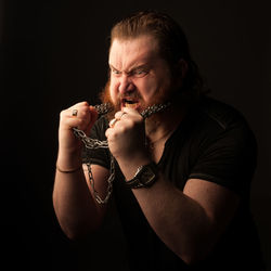 Portrait of mid adult man against black background