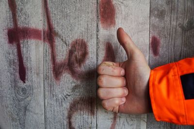 Midsection of person against orange wall