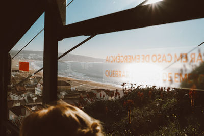 Text on glass window against sky