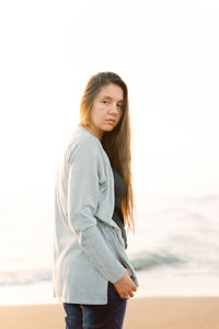 Portrait of young woman standing at beach