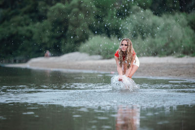 Full length of woman splashing water