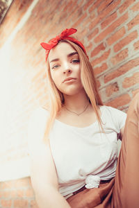 Portrait of a beautiful young woman against wall