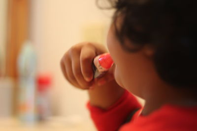 Close-up of boy applying lip balm