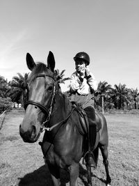 Kid riding horse on field