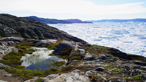 Scenic view of sea and mountains against sky