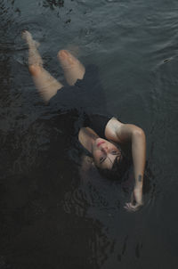 High angle view of woman lying in sea
