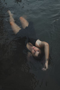 High angle view of woman lying in water