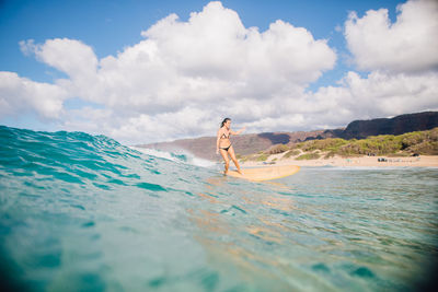 Man surfing in sea against sky