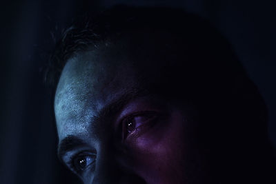 Close-up portrait of man against black background