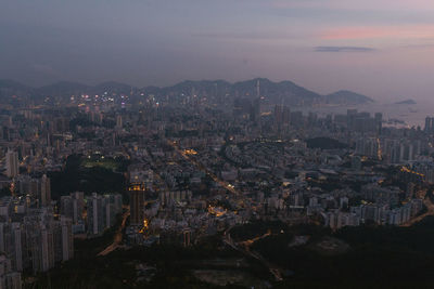 High angle view of illuminated cityscape against sky at dusk