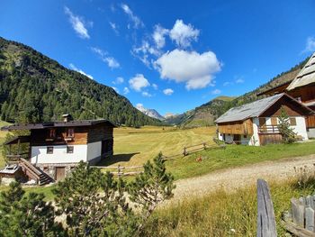 Scenic view of house and mountains against sky