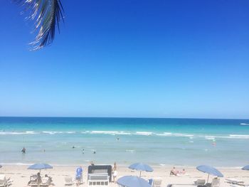 Scenic view of beach against clear blue sky