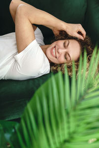 Low angle view of young woman lying on plant