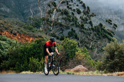 Rear view of man riding bicycle on mountain