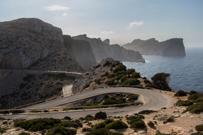 Scenic view of road by sea against sky