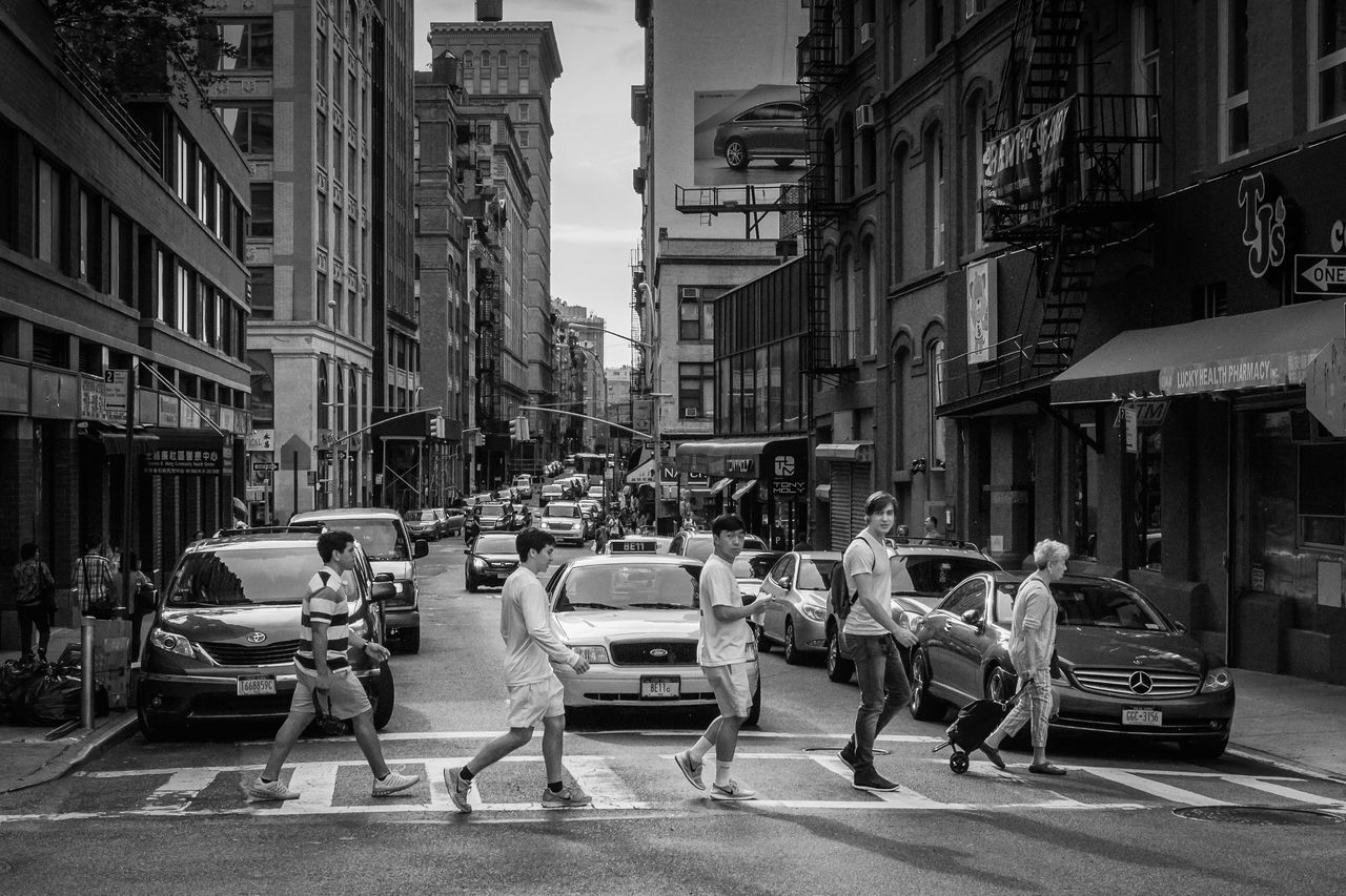 building exterior, city, architecture, built structure, street, car, transportation, city life, land vehicle, mode of transport, city street, incidental people, road, building, men, person, day, sunlight, outdoors