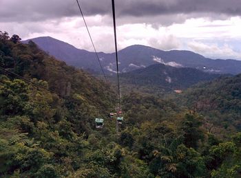 Overhead cable car over mountains against sky