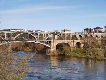 Arch bridge over river against sky