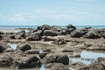 Panoramic shot of rocks on beach against sky