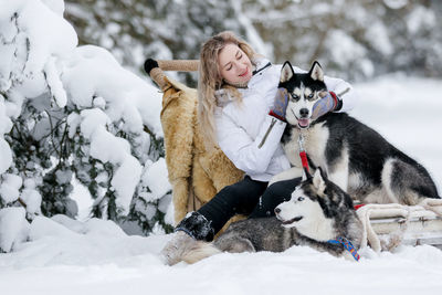 Woman with dogs on snow covered land