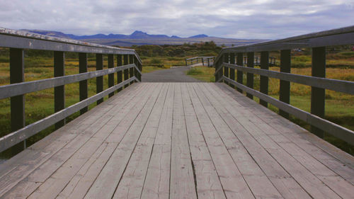 Footbridge amidst mountains against sky