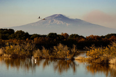 Scenic view of lake and mountains against sky