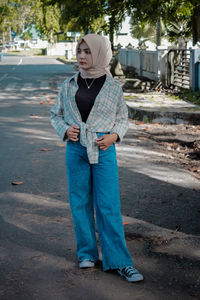 Full length of teenage girl standing on footpath in city