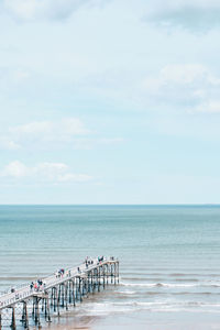 Group of people on beach against sky