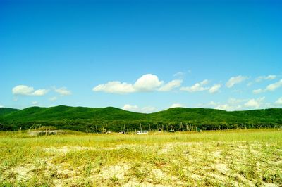 Scenic view of grassy field against cloudy sky