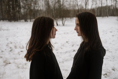 Young women standing on snow outdoors