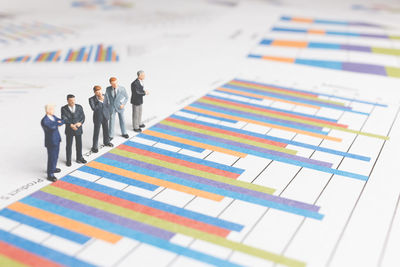 Close-up of businessmen figurines on bar graph